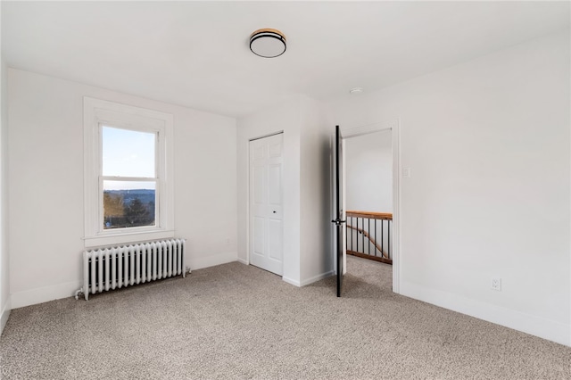 carpeted empty room with radiator heating unit