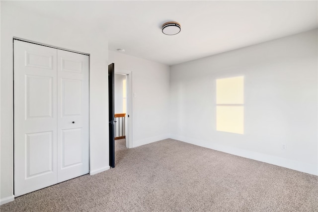 unfurnished bedroom featuring carpet flooring and a closet