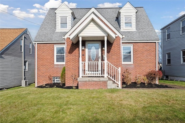 cape cod house with central AC and a front lawn