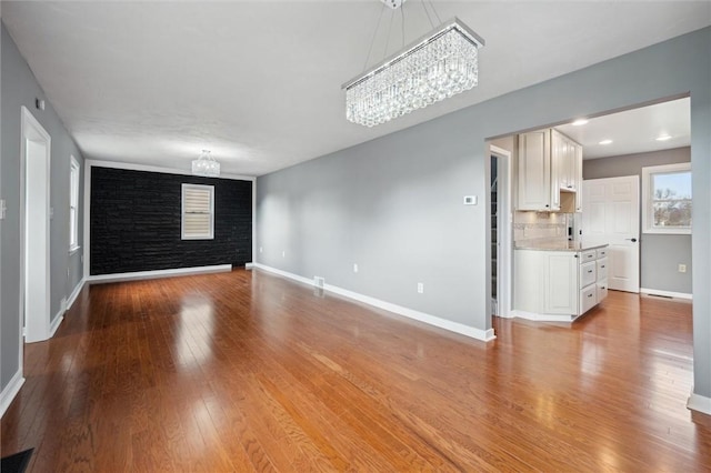 unfurnished living room featuring light hardwood / wood-style floors and an inviting chandelier