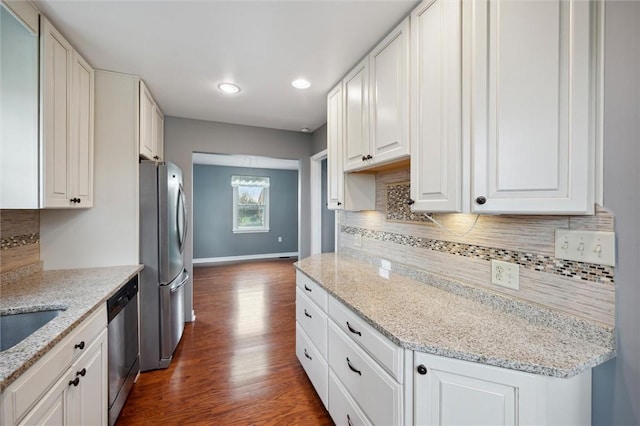 kitchen featuring white cabinets, stainless steel appliances, light stone counters, and dark hardwood / wood-style floors