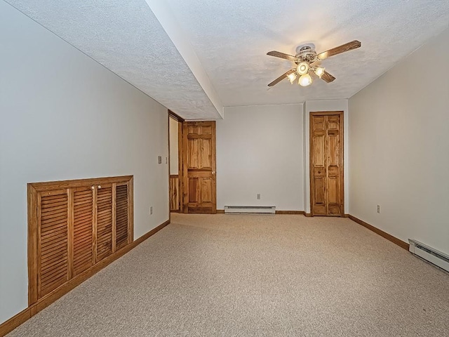 spare room featuring ceiling fan, carpet floors, a textured ceiling, and a baseboard heating unit