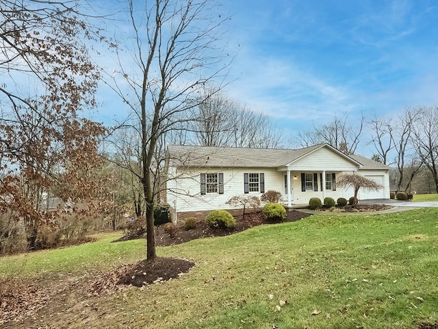 single story home with covered porch, a front yard, and a garage