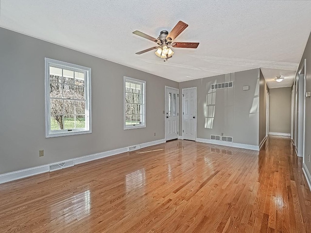 interior space featuring ceiling fan, a textured ceiling, and light wood-type flooring