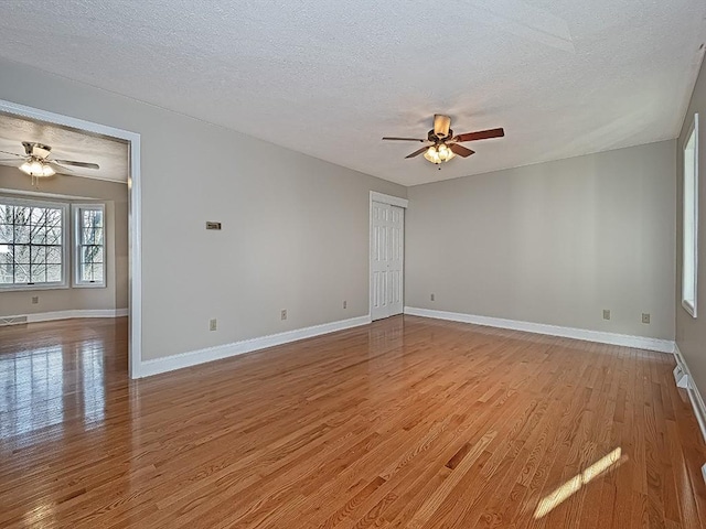 spare room featuring ceiling fan, a textured ceiling, and light hardwood / wood-style flooring