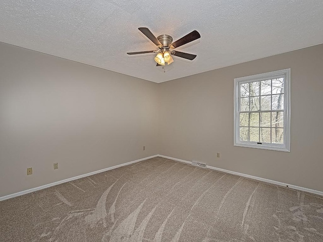 empty room featuring carpet, ceiling fan, and a textured ceiling