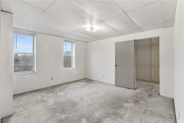 unfurnished bedroom featuring a closet, light carpet, and multiple windows