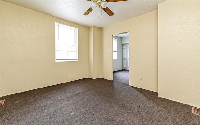 carpeted spare room featuring ceiling fan