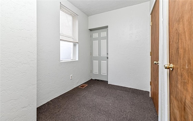 carpeted spare room with a textured ceiling