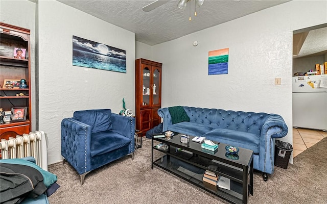 carpeted living room featuring ceiling fan, radiator heating unit, and a textured ceiling