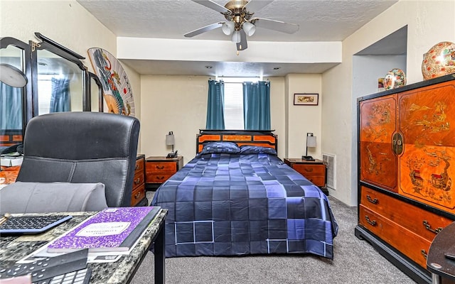 bedroom featuring ceiling fan, carpet floors, and a textured ceiling