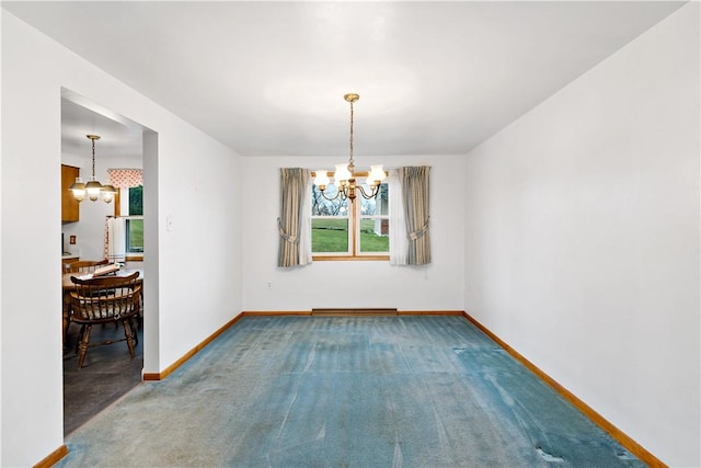 carpeted spare room with a chandelier