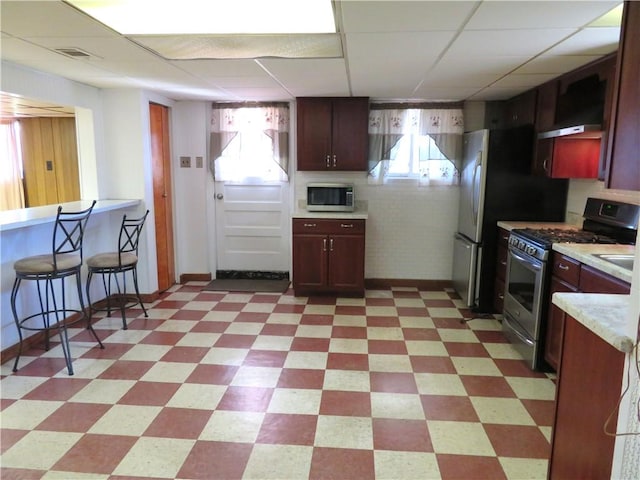 kitchen with a paneled ceiling and stainless steel appliances