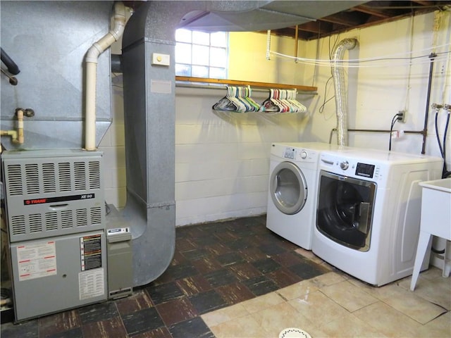 clothes washing area with separate washer and dryer and heating unit