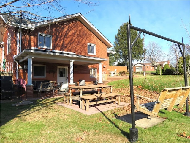 rear view of property featuring a yard and a patio area