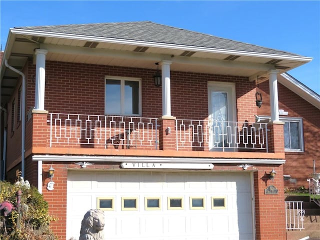 rear view of house with a garage and a balcony