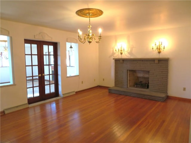 unfurnished living room featuring baseboard heating, a fireplace, french doors, and hardwood / wood-style flooring