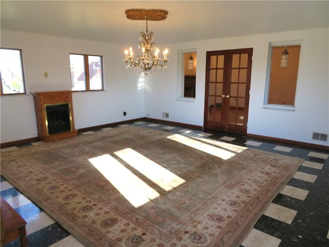 unfurnished living room with french doors and an inviting chandelier