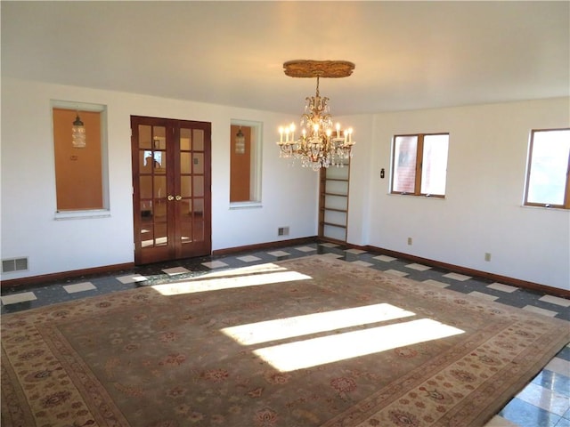 unfurnished room with a chandelier, french doors, and a healthy amount of sunlight