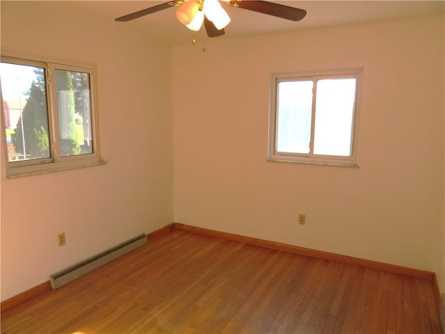 spare room with hardwood / wood-style floors, a baseboard radiator, plenty of natural light, and ceiling fan