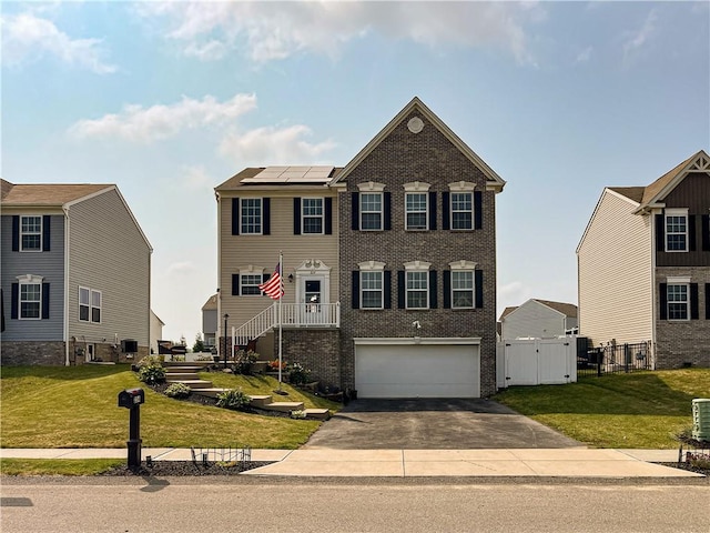 view of front of home with a garage, a front yard, and solar panels