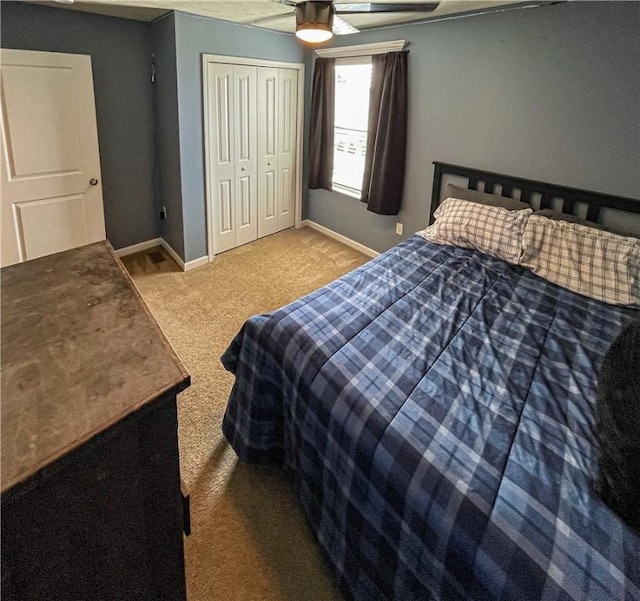 carpeted bedroom with ceiling fan and a closet