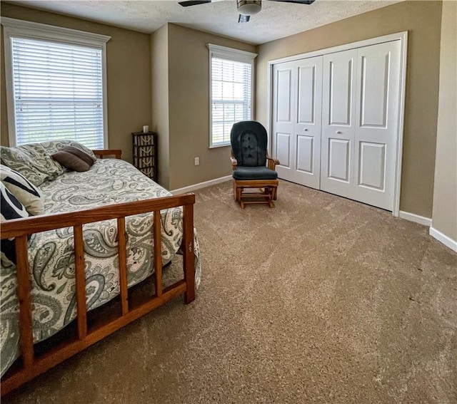 carpeted bedroom with a textured ceiling, a closet, and ceiling fan