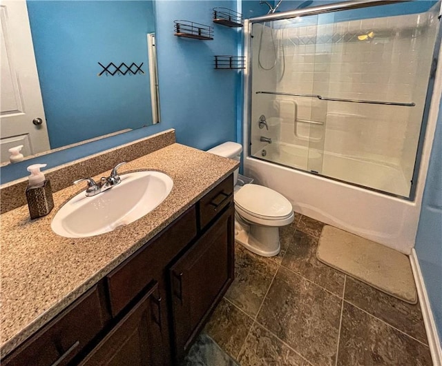 full bathroom featuring vanity, combined bath / shower with glass door, and toilet