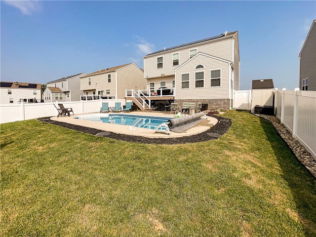 back of house featuring a yard, a patio area, and a pool side deck