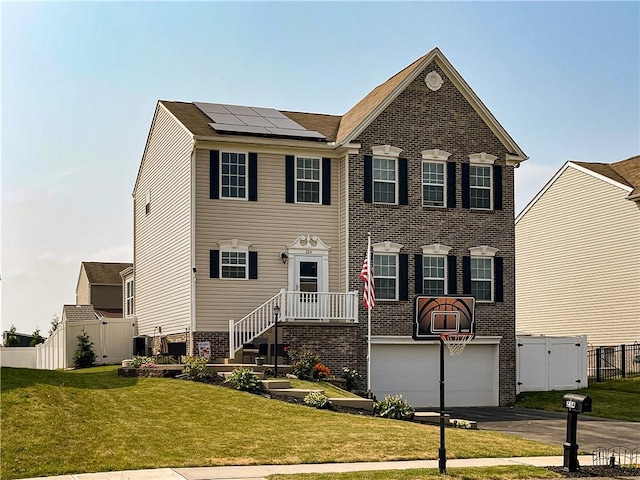 colonial inspired home with a front yard, solar panels, central AC, and a garage