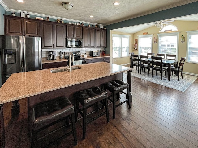 kitchen with sink, dark wood-type flooring, tasteful backsplash, crown molding, and appliances with stainless steel finishes