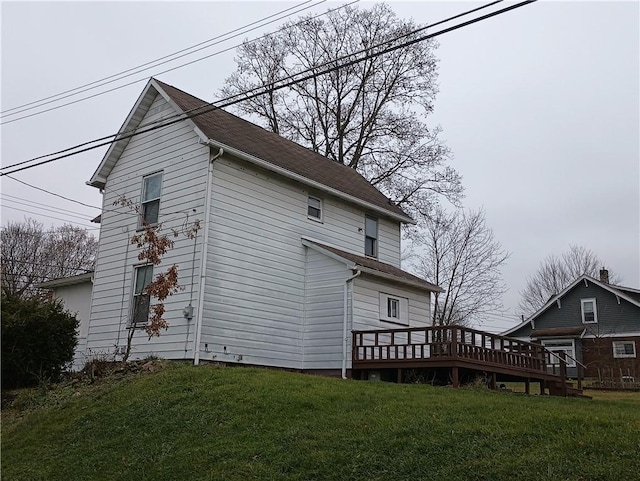 rear view of property featuring a deck and a yard