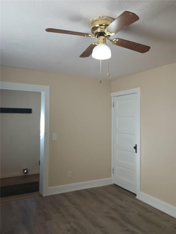 empty room featuring dark hardwood / wood-style flooring and ceiling fan