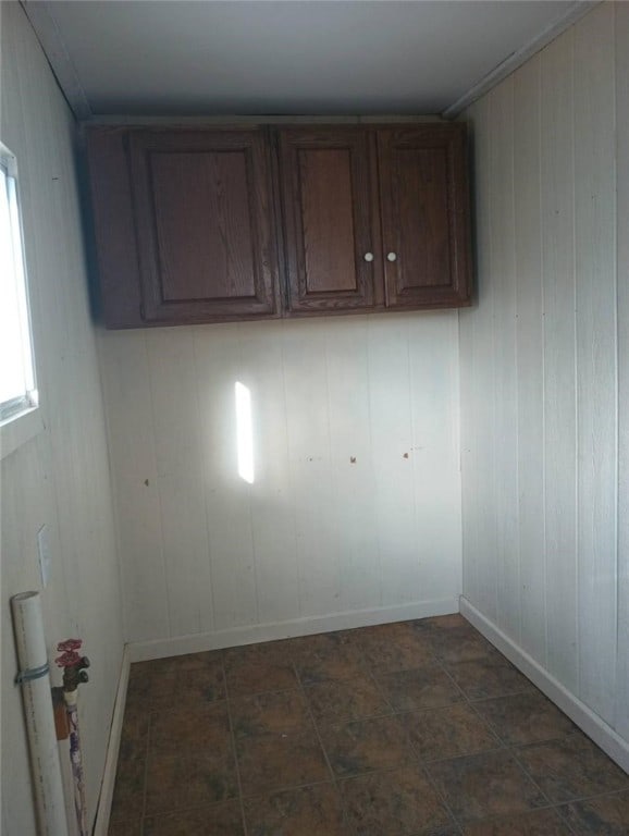 clothes washing area featuring wood walls