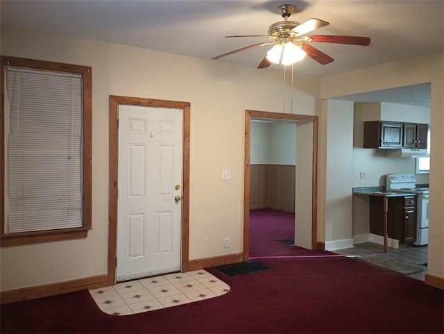 entryway with ceiling fan and light carpet