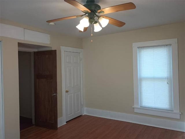 unfurnished room with ceiling fan and dark wood-type flooring