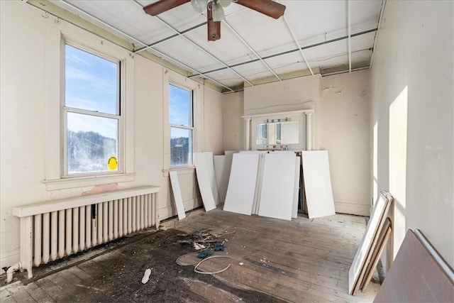 miscellaneous room featuring radiator heating unit, ceiling fan, and hardwood / wood-style floors