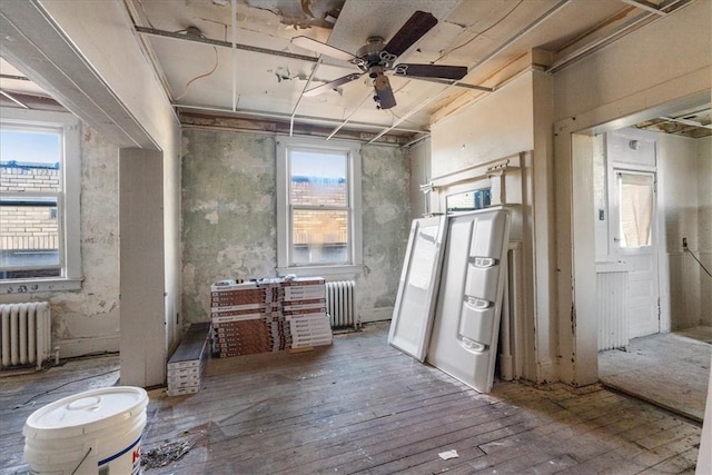 miscellaneous room featuring ceiling fan, radiator heating unit, and hardwood / wood-style flooring