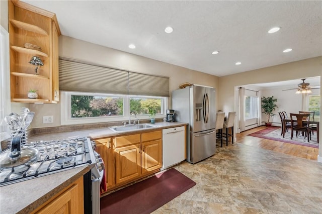 kitchen featuring dishwasher, a wealth of natural light, range, stainless steel refrigerator with ice dispenser, and sink