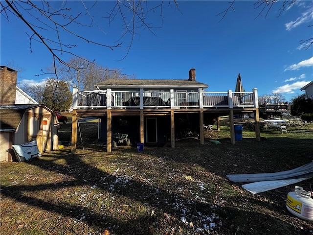 back of house featuring a storage unit and a deck