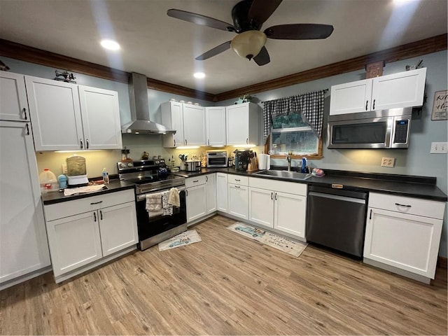 kitchen featuring white cabinets, light wood-type flooring, stainless steel appliances, and wall chimney exhaust hood