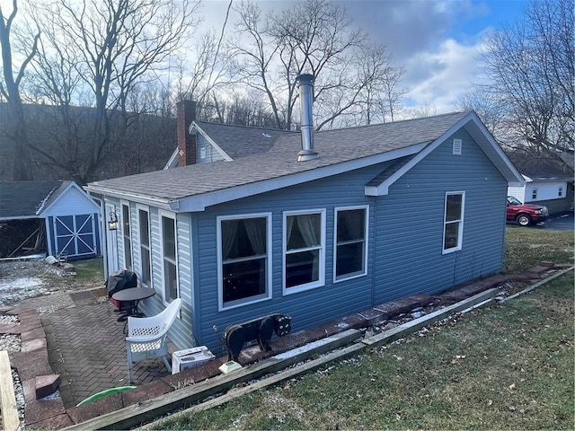 back of property with a storage shed