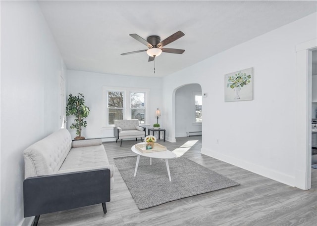 living room featuring light hardwood / wood-style flooring, ceiling fan, and a baseboard heating unit