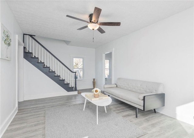 living room featuring a textured ceiling, hardwood / wood-style flooring, and ceiling fan