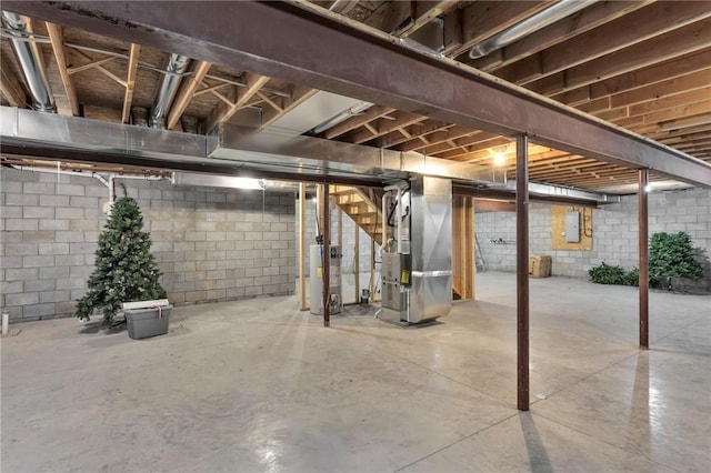 basement with heating unit, water heater, and electric panel