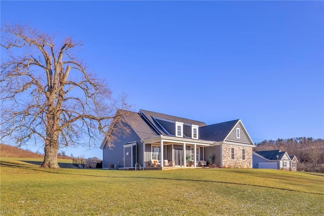 view of property featuring covered porch and a front yard