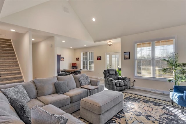 living room with hardwood / wood-style floors, high vaulted ceiling, and a chandelier