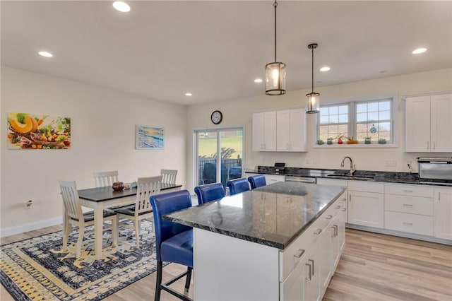 kitchen with plenty of natural light, a kitchen island, light hardwood / wood-style flooring, and sink