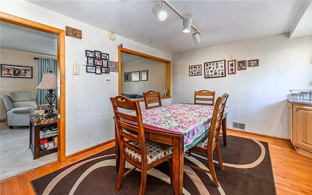 dining area featuring light hardwood / wood-style floors and rail lighting