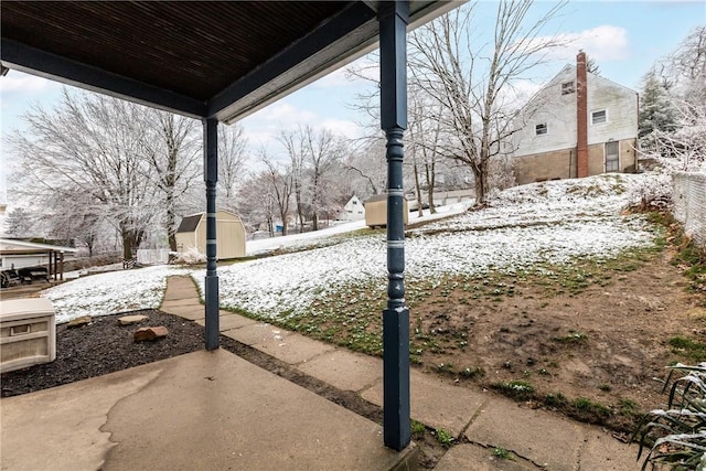 yard covered in snow with a storage unit